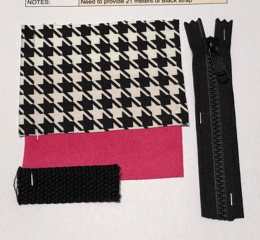 Fabric swatch with houndstooth pattern, pink lining, black zipper, and black strap on a white background.