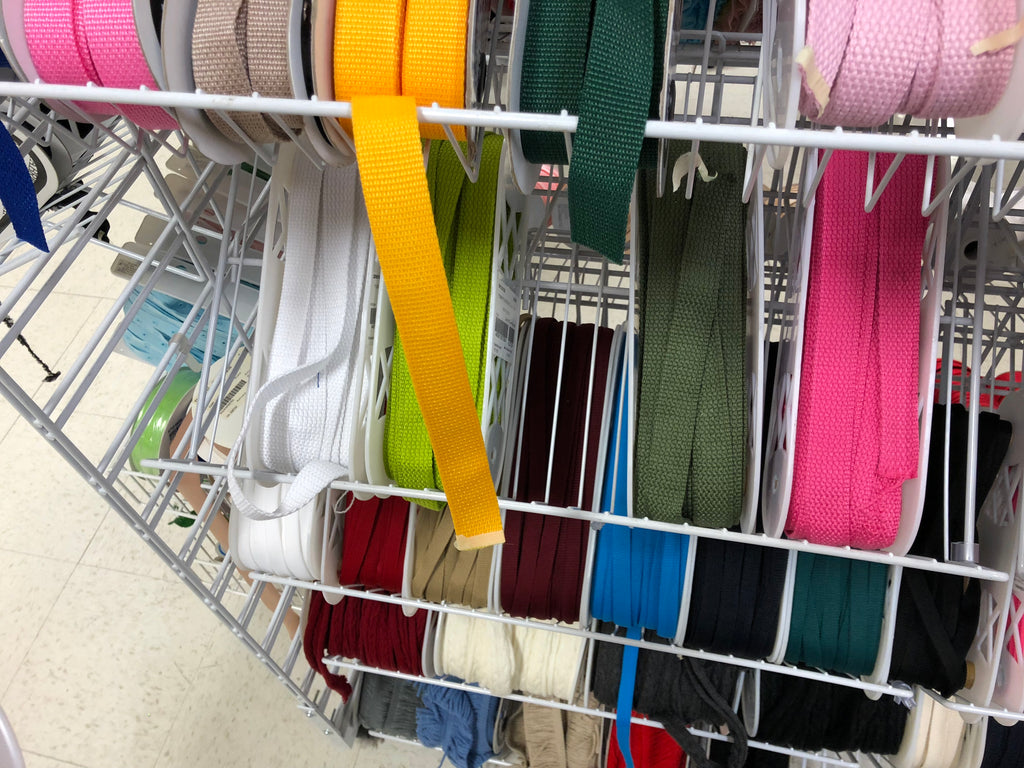Assorted colorful ribbons on a metal rack.